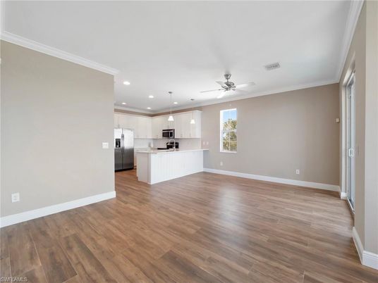 Empty room, Interior, Kitchen, Pendant Lights, Recessed Lighting, Stainless Steel Appliances, Wood Texture Flooring