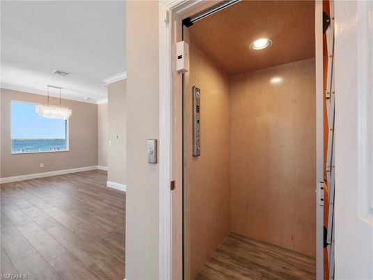 Chandelier, Elevator, Interior, Recessed Lighting, Wood Texture Flooring, Wooden Walls
