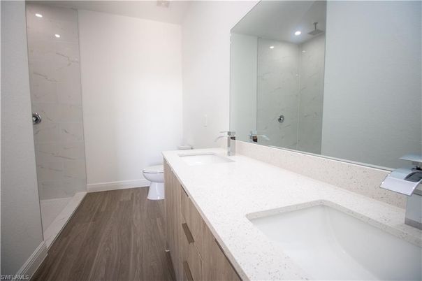 Bathroom, Dual Sink Vanities, Glass Shower, Interior, Marble Walls, Recessed Lighting, Wood Texture Flooring