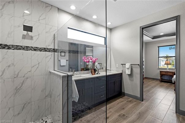 Bathroom, Dual Sink Vanities, Glass Shower, Interior, Marble Walls, Recessed Lighting, Wood Texture Flooring