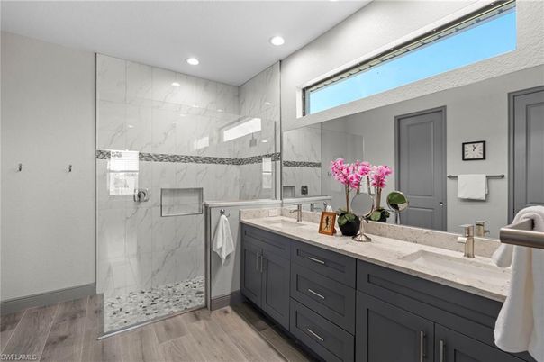 Bathroom, Dual Sink Vanities, Glass Shower, Interior, Marble Walls, Recessed Lighting, Wood Texture Flooring