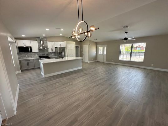 Chandelier, Empty room, Interior, Kitchen, Pendant Lights, Recessed Lighting, Stainless Steel Appliances, Wood Texture Flooring