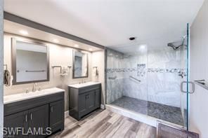 Bathroom, Dual Sink Vanities, Glass Shower, Interior, Marble Walls, Recessed Lighting, Wood Texture Flooring