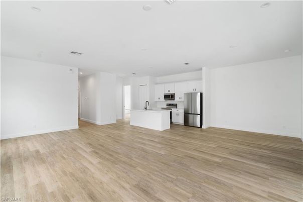 Empty room, Interior, Kitchen, Recessed Lighting, Stainless Steel Appliances, Wood Texture Flooring