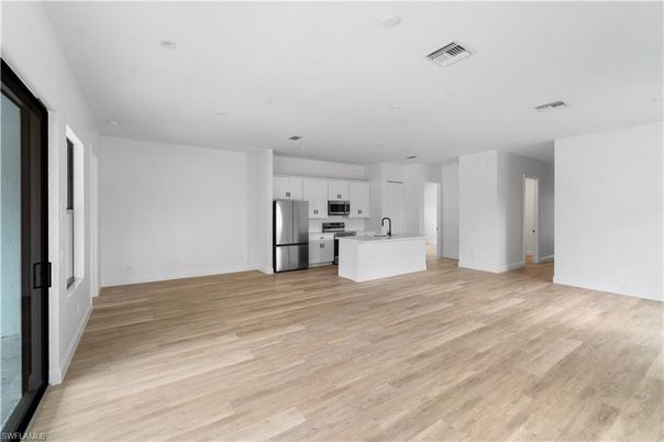 Empty room, Interior, Kitchen, Recessed Lighting, Stainless Steel Appliances, Wood Texture Flooring