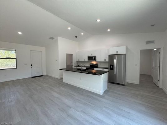 Empty room, Interior, Kitchen, Recessed Lighting, Stainless Steel Appliances, Wood Texture Flooring