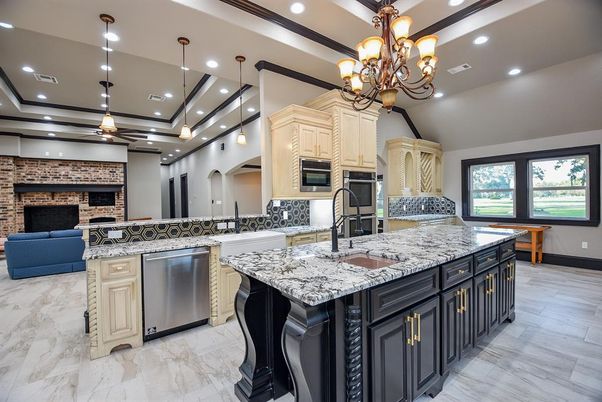 Chandelier, Fireplace, Interior, Kitchen, Marble, Pendant Lights, Recessed Lighting, Stainless Steel Appliances, Stone Walls, Wood Texture Flooring