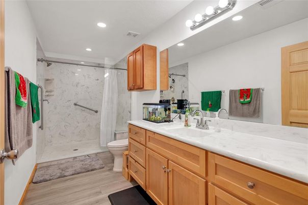 Bathroom, Dual Sink Vanities, Glass Shower, Interior, Marble Walls, Recessed Lighting, Wood Texture Flooring