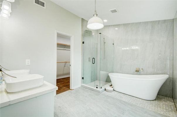 Bathroom, Free Standing Baths, Glass Shower, Interior, Marble Walls, Pendant Lights, Recessed Lighting, Wood Texture Flooring
