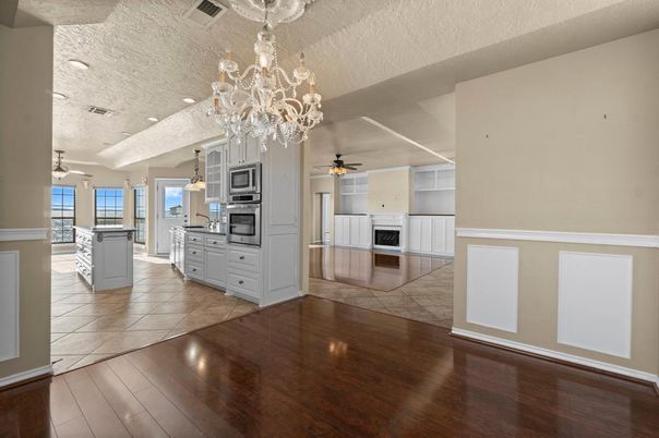 Chandelier, Fireplace, Interior, Kitchen, Recessed Lighting, Stainless Steel Appliances, Wood Texture Flooring