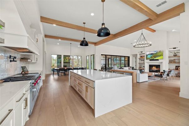 Chandelier, Dining room, Fireplace, Interior, Kitchen, Living room, Pendant Lights, Recessed Lighting, Stainless Steel Appliances, Wooden Beams, Wood Texture Flooring