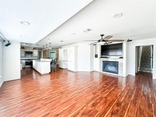 Chandelier, Empty room, Fireplace, Interior, Kitchen, Recessed Lighting, Stainless Steel Appliances, Wood Texture Flooring