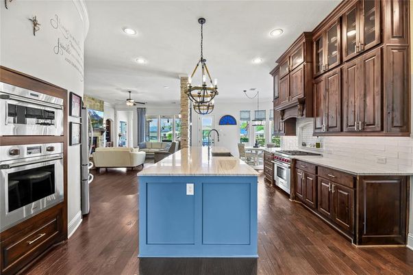 Chandelier, Dining room, Interior, Kitchen, Living room, Pendant Lights, Recessed Lighting, Stainless Steel Appliances, Wood Texture Flooring