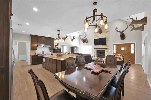 Dining room, Fireplace, Interior, Kitchen, Pendant Lights, Recessed Lighting, Stainless Steel Appliances, Stone Walls, Wood Texture Flooring