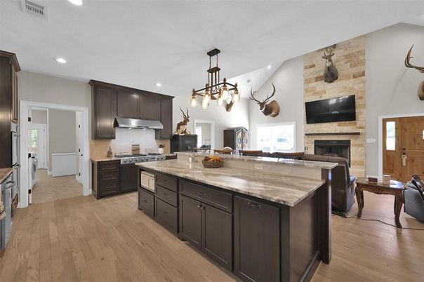 Fireplace, Interior, Kitchen, Pendant Lights, Recessed Lighting, Stainless Steel Appliances, Stone Walls, Wood Texture Flooring