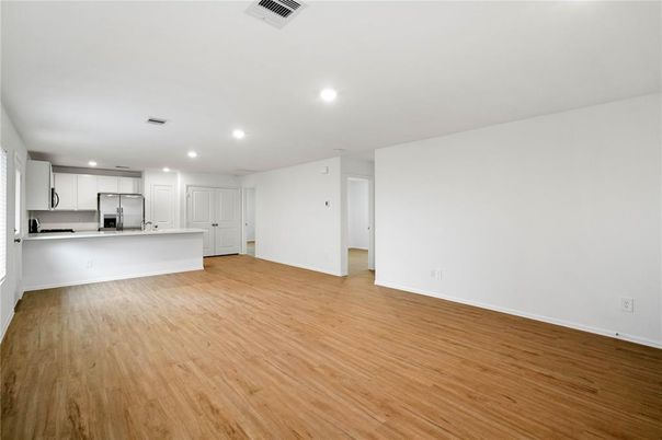 Empty room, Interior, Kitchen, Recessed Lighting, Stainless Steel Appliances, Wood Texture Flooring