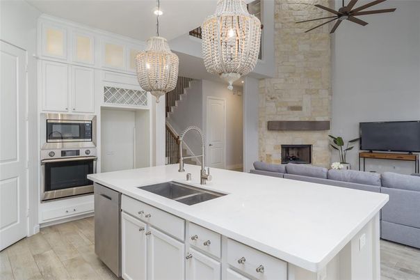 Chandelier, Fireplace, Interior, Kitchen, Pendant Lights, Stainless Steel Appliances, Stone Walls, Wood Texture Flooring