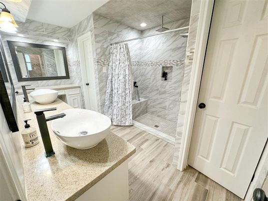 Bathroom, Dual Sink Vanities, Free Standing Baths, Glass Shower, Interior, Marble Walls, Recessed Lighting, Wood Texture Flooring