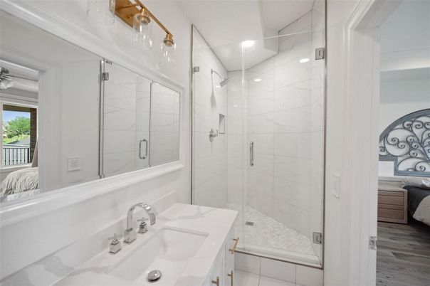 Bathroom, Dual Sink Vanities, Glass Shower, Interior, Marble Walls, Recessed Lighting, Wood Texture Flooring
