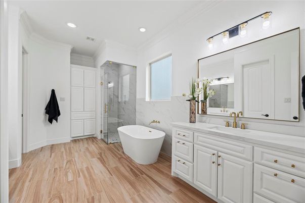 Bathroom, Dual Sink Vanities, Free Standing Baths, Glass Shower, Interior, Marble Walls, Recessed Lighting, Wood Texture Flooring