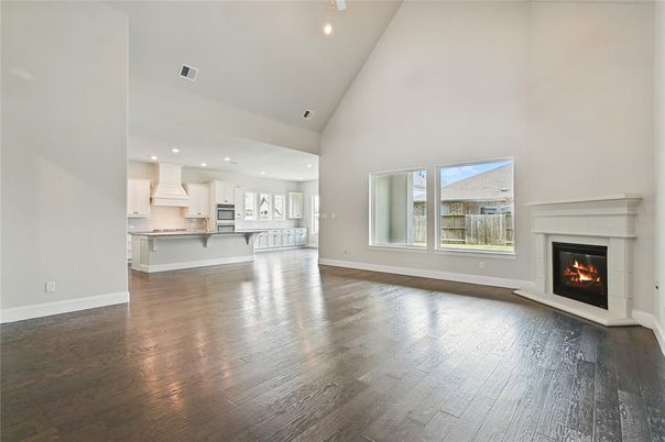 Empty room, Fireplace, Interior, Kitchen, Recessed Lighting, Stainless Steel Appliances, Wood Texture Flooring