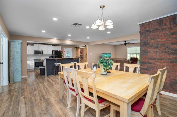 Chandelier, Dining room, Interior, Kitchen, Recessed Lighting, Stainless Steel Appliances, Stone Walls, Wood Texture Flooring
