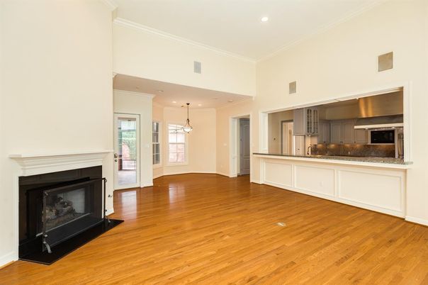 Empty room, Fireplace, Interior, Kitchen, Pendant Lights, Recessed Lighting, Stainless Steel Appliances, Wood Texture Flooring
