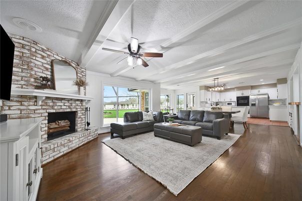 Chandelier, Dining room, Fireplace, Interior, Kitchen, Living room, Pendant Lights, Stainless Steel Appliances, Stone Walls, Wood Texture Flooring