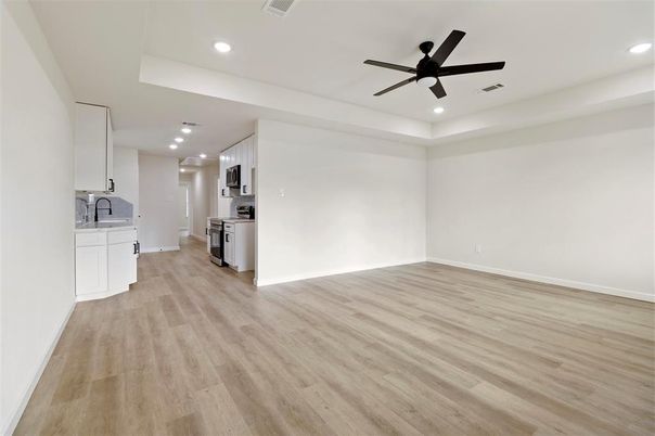 Empty room, Interior, Kitchen, Recessed Lighting, Stainless Steel Appliances, Wood Texture Flooring