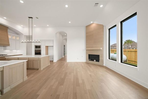 Empty room, Fireplace, Interior, Kitchen, Pendant Lights, Recessed Lighting, Stainless Steel Appliances, Wood Texture Flooring