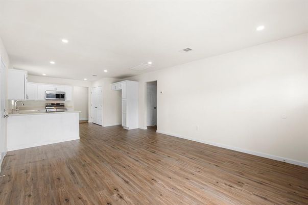 Empty room, Interior, Kitchen, Recessed Lighting, Stainless Steel Appliances, Wood Texture Flooring