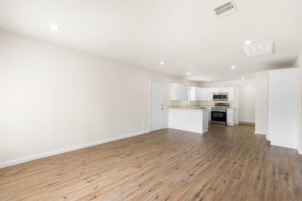 Empty room, Interior, Kitchen, Recessed Lighting, Stainless Steel Appliances, Wood Texture Flooring