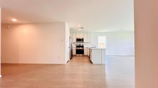 Empty room, Interior, Kitchen, Recessed Lighting, Stainless Steel Appliances, Wood Texture Flooring