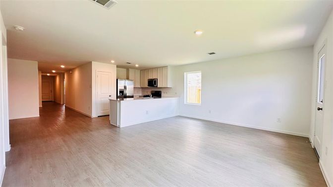 Empty room, Interior, Kitchen, Recessed Lighting, Stainless Steel Appliances, Wood Texture Flooring