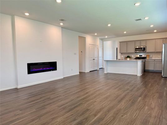 Empty room, Fireplace, Interior, Kitchen, Recessed Lighting, Stainless Steel Appliances, Wood Texture Flooring