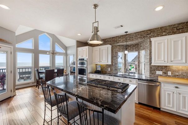 Dining room, Interior, Kitchen, Pendant Lights, Recessed Lighting, Stainless Steel Appliances, Stone Walls, Water, Wood Texture Flooring