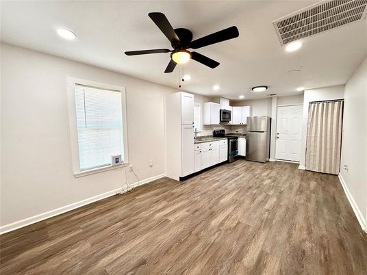 Empty room, Interior, Kitchen, Recessed Lighting, Stainless Steel Appliances, Wood Texture Flooring