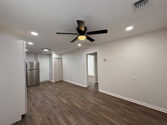 Empty room, Interior, Kitchen, Recessed Lighting, Stainless Steel Appliances, Wood Texture Flooring