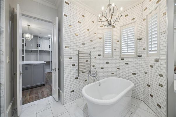 Bathroom, Chandelier, Dual Sink Vanities, Free Standing Baths, Interior, Marble, Pendant Lights, Stone Walls, Wood Texture Flooring