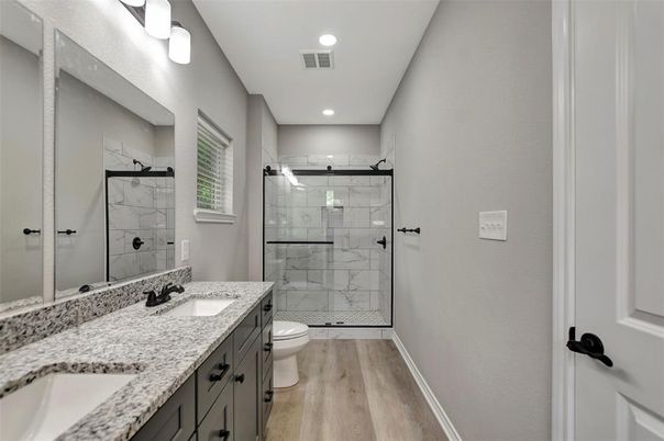Bathroom, Dual Sink Vanities, Glass Shower, Interior, Marble Walls, Recessed Lighting, Wood Texture Flooring