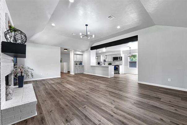 Empty room, Fireplace, Interior, Kitchen, Pendant Lights, Recessed Lighting, Stainless Steel Appliances, Wood Texture Flooring