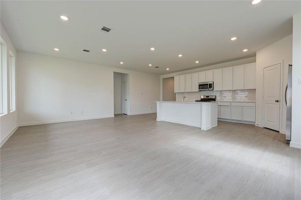 Empty room, Interior, Kitchen, Recessed Lighting, Stainless Steel Appliances, Wood Texture Flooring
