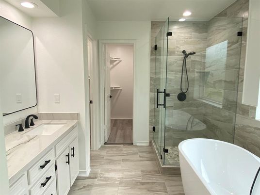 Bathroom, Dual Sink Vanities, Free Standing Baths, Glass Shower, Interior, Marble Walls, Recessed Lighting, Wood Texture Flooring