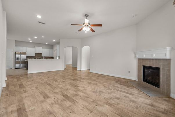 Empty room, Fireplace, Interior, Kitchen, Recessed Lighting, Stainless Steel Appliances, Wood Texture Flooring