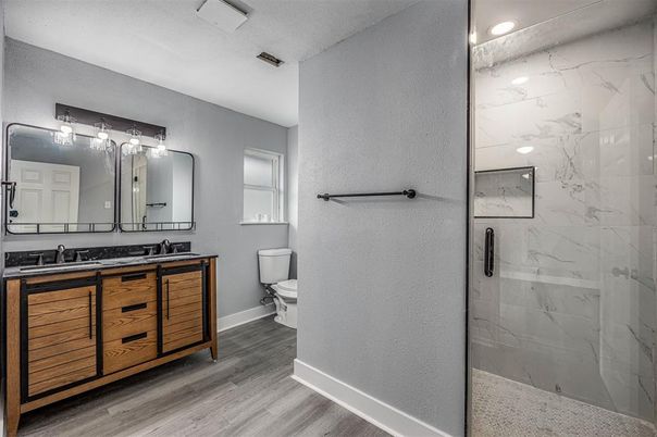 Bathroom, Dual Sink Vanities, Glass Shower, Interior, Marble Walls, Recessed Lighting, Wood Texture Flooring