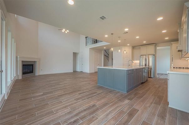 Empty room, Fireplace, Interior, Kitchen, Pendant Lights, Recessed Lighting, Stainless Steel Appliances, Wood Texture Flooring