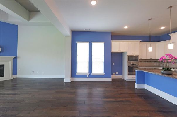 Empty room, Fireplace, Interior, Kitchen, Pendant Lights, Recessed Lighting, Stainless Steel Appliances, Wood Texture Flooring