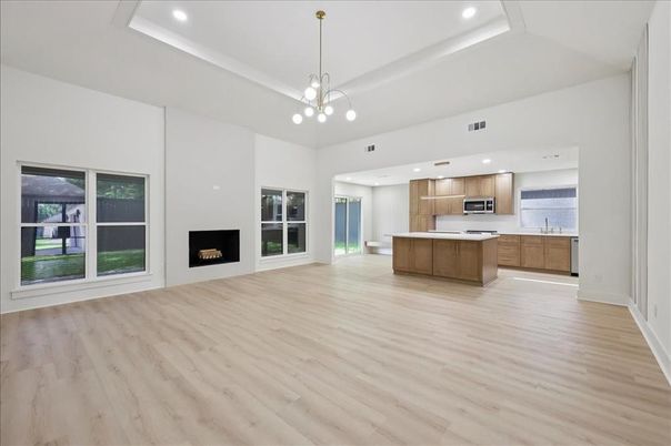 Empty room, Fireplace, Interior, Kitchen, Pendant Lights, Recessed Lighting, Stainless Steel Appliances, Wood Texture Flooring