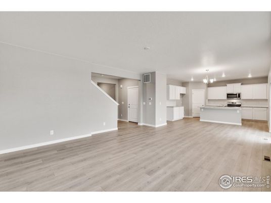 Chandelier, Empty room, Interior, Kitchen, Recessed Lighting, Stainless Steel Appliances, Wood Texture Flooring