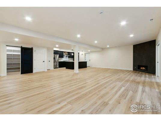 Empty room, Fireplace, Interior, Kitchen, Recessed Lighting, Stainless Steel Appliances, Wood Texture Flooring